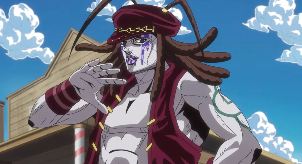 A pale man with long brown dreadlocks, a red cap, purple face markings and a cropped red vest raises one hand on a sunny frontier street, in a still from Steel Ball Run: JoJo's Bizarre Adventure episode 5